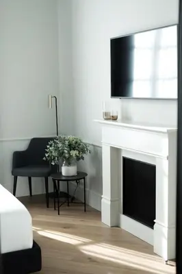 a living room with a white fireplace and a tv at Maldà Singular Hotel in Barcelona