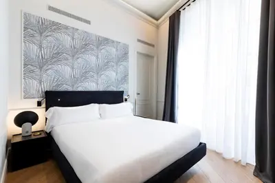 a bedroom with a white bed and a large window at Maldà Singular Hotel in Barcelona