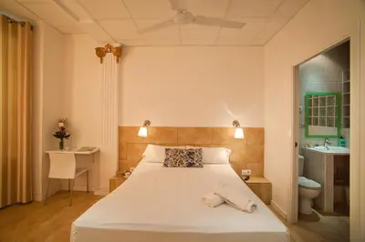 a bedroom with a white bed and a bathroom at Hostal Martinval in Barcelona