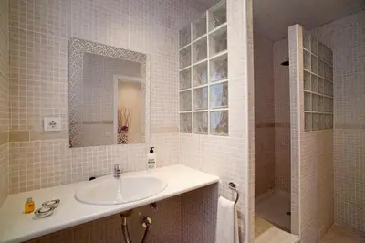 a white bathroom with a sink and a shower at Hostal Martinval in Barcelona