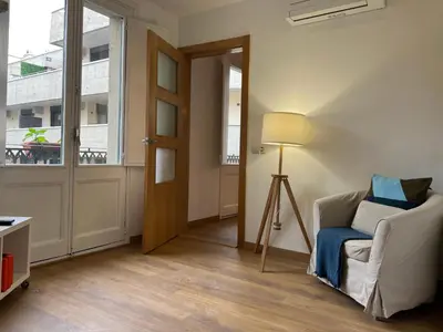 a room with a door and a chair and a lamp at Ripoll Apartments in Barcelona