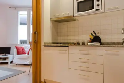 a kitchen with white cabinets and a microwave at Ripoll Apartments in Barcelona