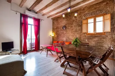 a living room with a table and a brick wall at Apartamentos El Pintor in Barcelona