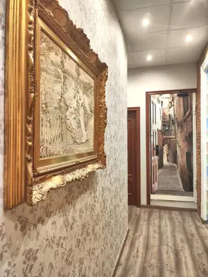 a painting hanging on a wall in a hallway at Hostal Orleans in Barcelona