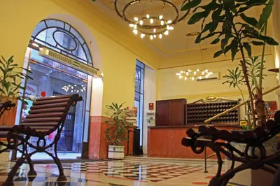 a lobby with a bench and a organ in a building at Hotel Peninsular in Barcelona