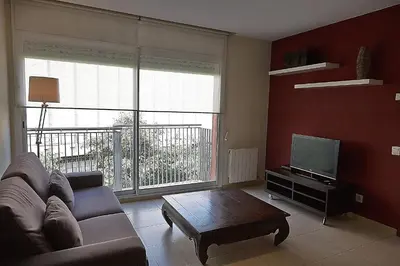 a living room with a couch and a tv at Alguera Apartments Sant Andreu in Barcelona