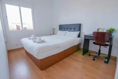 a bedroom with a bed and a desk and a chair at Apartament Sagrada Familia in Barcelona