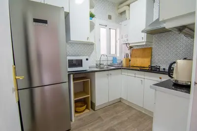 a kitchen with white cabinets and a refrigerator at Apartament Sagrada Familia in Barcelona