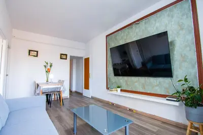a living room with a couch and a tv on a wall at Apartament Sagrada Familia in Barcelona