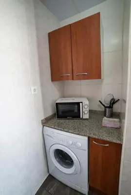 a kitchen with a washing machine and a microwave at Apartaments Atzavara in Calella