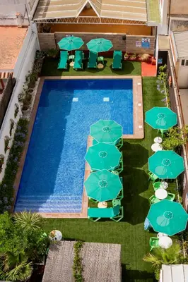 an overhead view of a swimming pool with blue umbrellas at Apartaments Atzavara in Calella