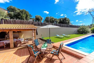 a patio with a table and chairs next to a swimming pool at Catalunya Casas Stunning modern villa and just half hour to Barcelona! in Caldes de Montbui