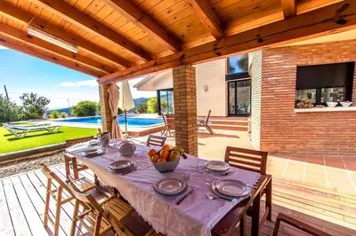 a table with a bowl of fruit on a patio at Catalunya Casas Stunning modern villa and just half hour to Barcelona! in Caldes de Montbui