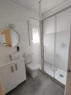 a white bathroom with a toilet and a shower at Estancia Rural Tranquila in Lliçà d'Amunt