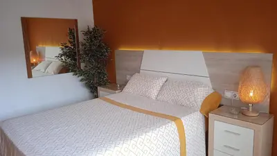 a bedroom with a white bed and a mirror at CALELLA DE LA COSTA ( Maresme - Costa Brava) in Calella