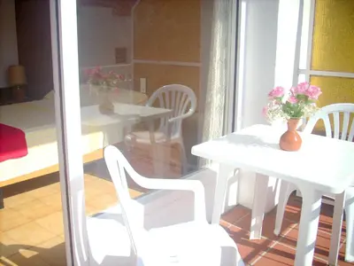 a white table and chairs with a vase of flowers on it at CALELLA DE LA COSTA ( Maresme - Costa Brava) in Calella
