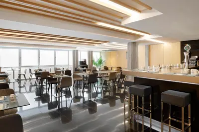 a restaurant with a bar with tables and chairs at Dorma Plaza Catalunya in Barcelona