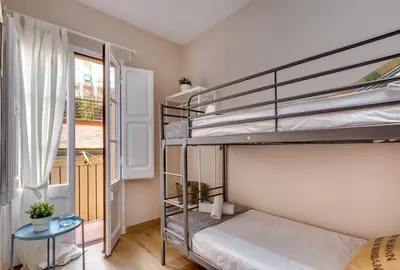 a bedroom with two bunk beds and a window at Renovated & Classic 3-Bedroom Sagrada Familia Apartment in Barcelona