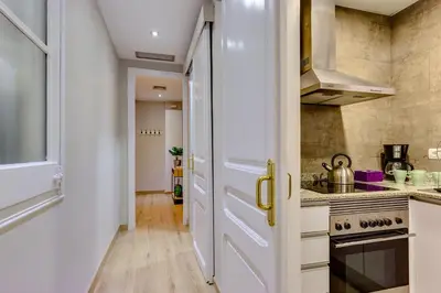 a kitchen with white cabinets and a stove top oven at Renovated & Classic 3-Bedroom Sagrada Familia Apartment in Barcelona