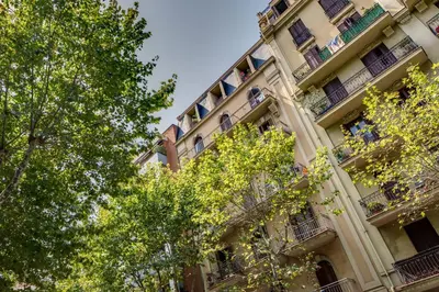an apartment building with trees in front of it at Renovated & Classic 3-Bedroom Sagrada Familia Apartment in Barcelona