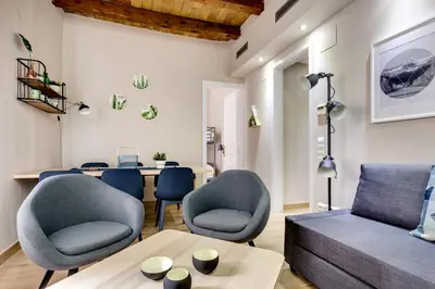 a living room with a table and chairs and a couch at Renovated & Classic 3-Bedroom Sagrada Familia Apartment in Barcelona
