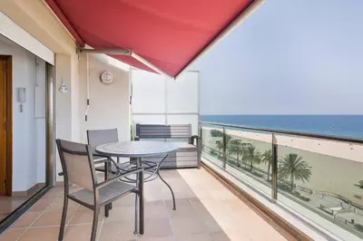 a balcony with a table and chairs and the ocean at Pis Ocata in Masnou