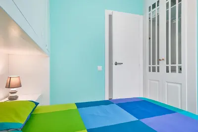 a bedroom with a colorful bed and a door at Pis Ocata in Masnou