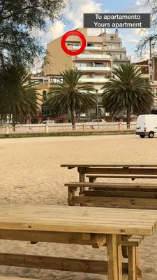 a wooden bench sitting on a beach next to a building at Pis Ocata in Masnou