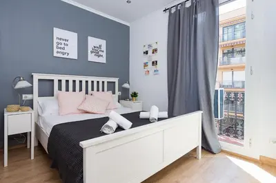 a bedroom with a bed with pink pillows and a window at Lovely and Convenient Sagrada Familia Apartment in Barcelona