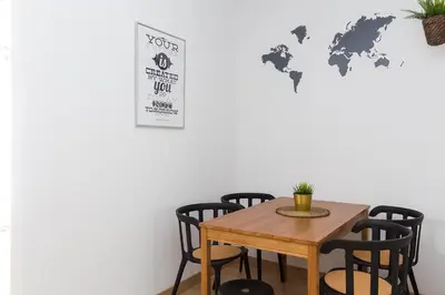 a table and chairs with a world map on the wall at Lovely and Convenient Sagrada Familia Apartment in Barcelona