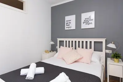 a bedroom with a white bed with pink pillows at Lovely and Convenient Sagrada Familia Apartment in Barcelona