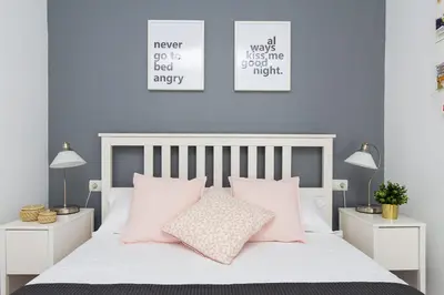 a bedroom with a white bed with pink pillows at Lovely and Convenient Sagrada Familia Apartment in Barcelona