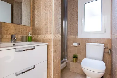 a bathroom with a toilet and a sink and a window at Lovely and Convenient Sagrada Familia Apartment in Barcelona