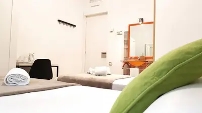 a room with two beds and a mirror at Hostal la Palmera in Barcelona