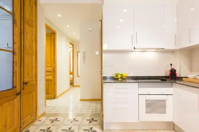 a kitchen with white cabinets and a counter top at Novus Homes Barcelona Gracia in Barcelona