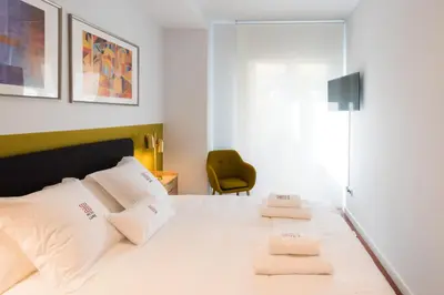 a bedroom with a white bed with two towels at Petit Luxe l'Oasi d'Egara in Terrassa