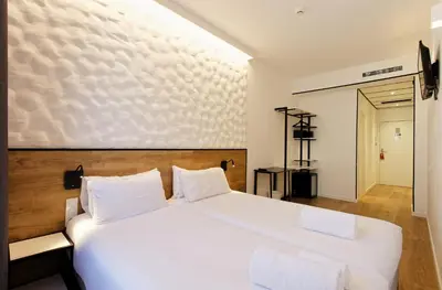 a bedroom with a large white bed with white pillows at Green House Hotel in Barcelona