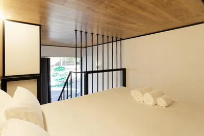 a bedroom with a white bed with two towels at Green House Hotel in Barcelona