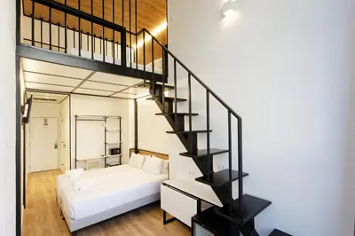 a living room with a white couch and a staircase at Green House Hotel in Barcelona