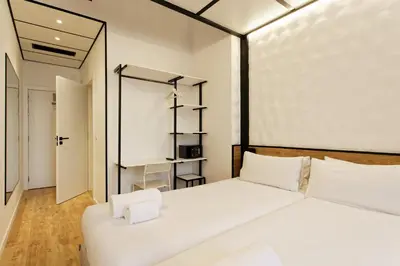 a bedroom with a large white bed with white pillows at Green House Hotel in Barcelona
