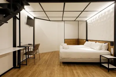 a bedroom with a bed and a table and chairs at Green House Hotel in Barcelona