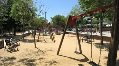 a playground with benches and swings in a park at CASA FLAMINGO in Masnou