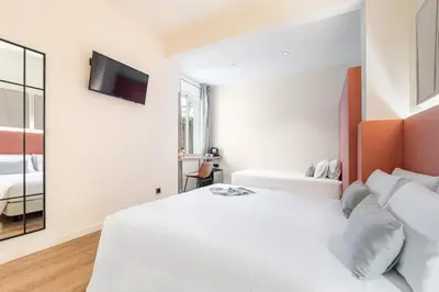 a bedroom with a white bed and a flat screen tv at LeMar by Aspasios in Barcelona