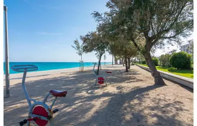 a balcony with a couch and a table and a chair at HomeHolidaysRentals Salvador in Pineda de Mar