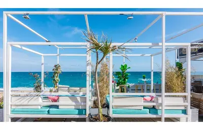 a pergola on a deck with the ocean in the background at HomeHolidaysRentals Salvador in Pineda de Mar