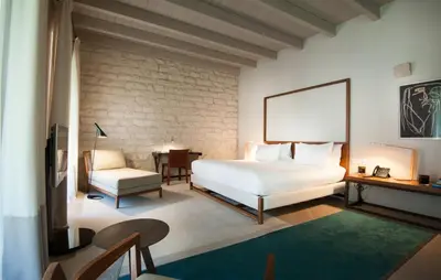 a bedroom with a large white bed and a chair at Mercer Hotel Barcelona in Barcelona