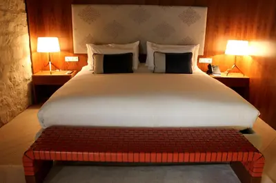 a large bed with a red bench in a room at Mercer Hotel Barcelona in Barcelona