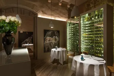 a restaurant with two tables and a large wall of wine bottles at Mercer Hotel Barcelona in Barcelona