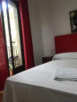 a bedroom with a white bed and a window at Pensión Teruel in Barcelona