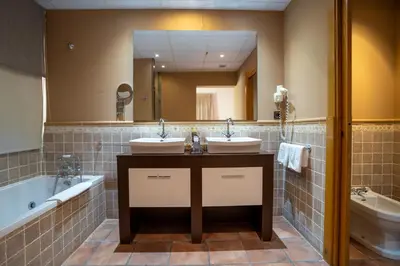 a bathroom with two sinks and a large mirror at Hotel & Spa Golden Barcelona in Vallromanas